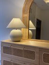 Handcrafted white terracotta lamp placed on a console in modern setting