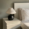 Compact round black lamp placed on side table