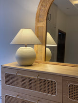 Handcrafted white terracotta lamp placed on a console in modern setting