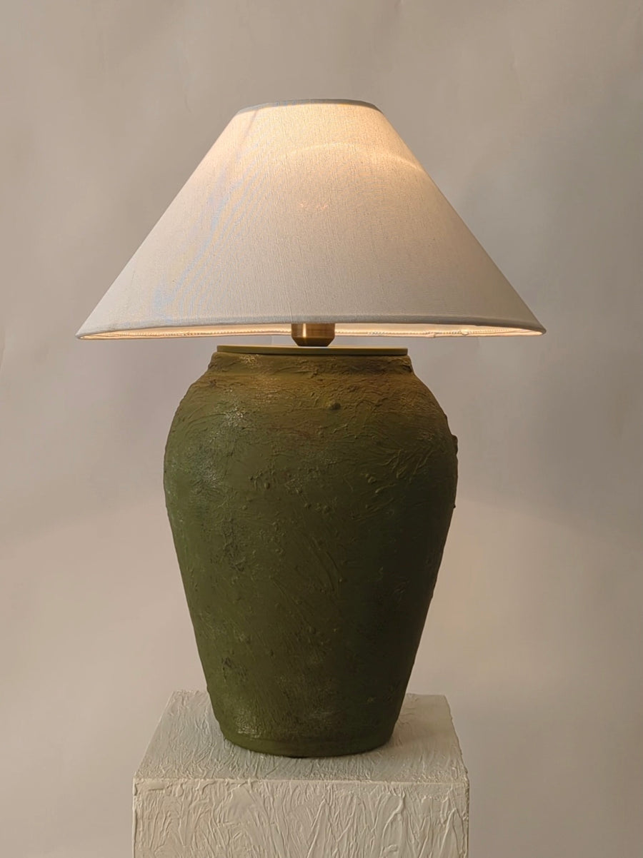 Olive green terracotta lamp in Pakistan with rust accent and artisan detail
