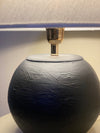 Close-up of handcrafted matte lamp with gold accessory detail

