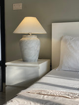 Softly glowing terracotta Cloud lamp styled on a side table

